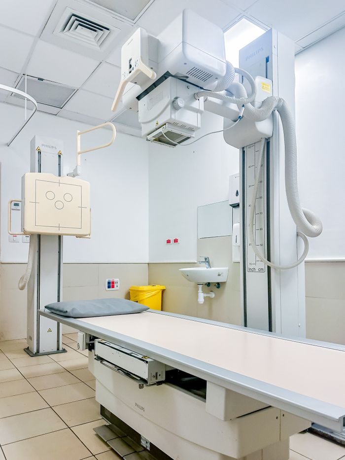 Bright, clean X-ray room in a hospital with advanced medical imaging equipment.